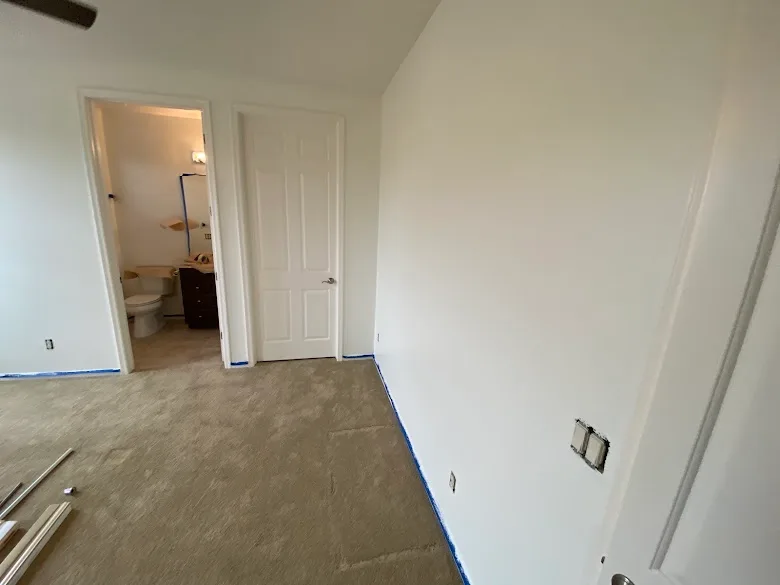 Bedroom walls painted with baseboards taped for clean lines