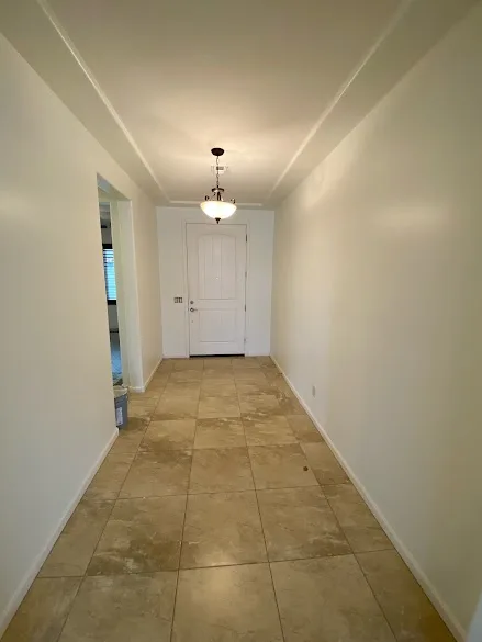 Long tiled hallway with freshly painted white walls