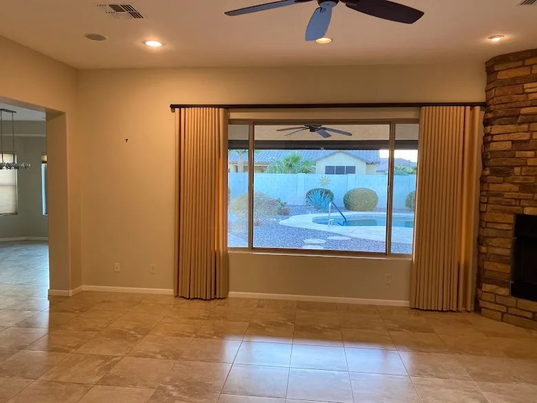Freshly painted living room with a large window and stone fireplace